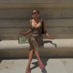 Mulher usando sandálias essenciais para o verão em look leve e elegante durante viagem em dia ensolarado